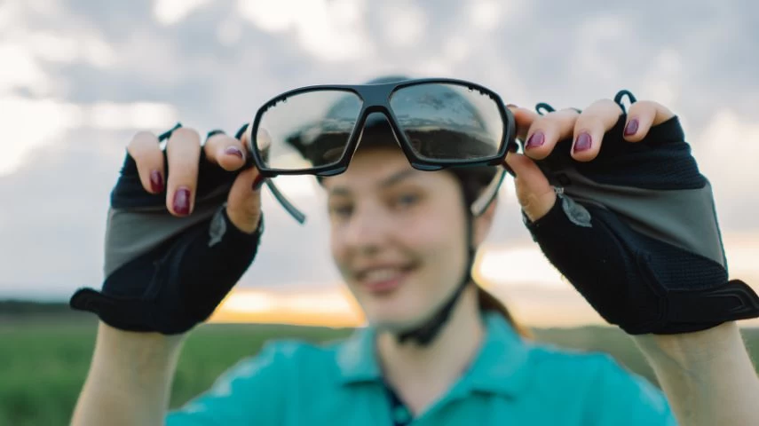 Devojka u rukama drži sportske naočare za vid.